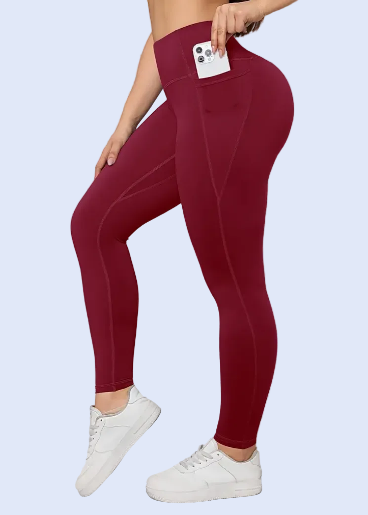 Person wearing maroon leggings with a white background