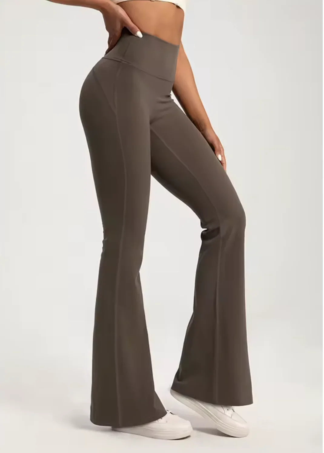 Woman wearing high-waisted brown flared activewear pants from GymDeity