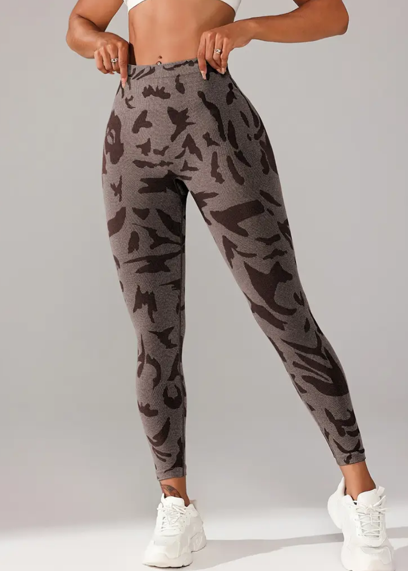 Camouflage leggings worn by a person on a plain background