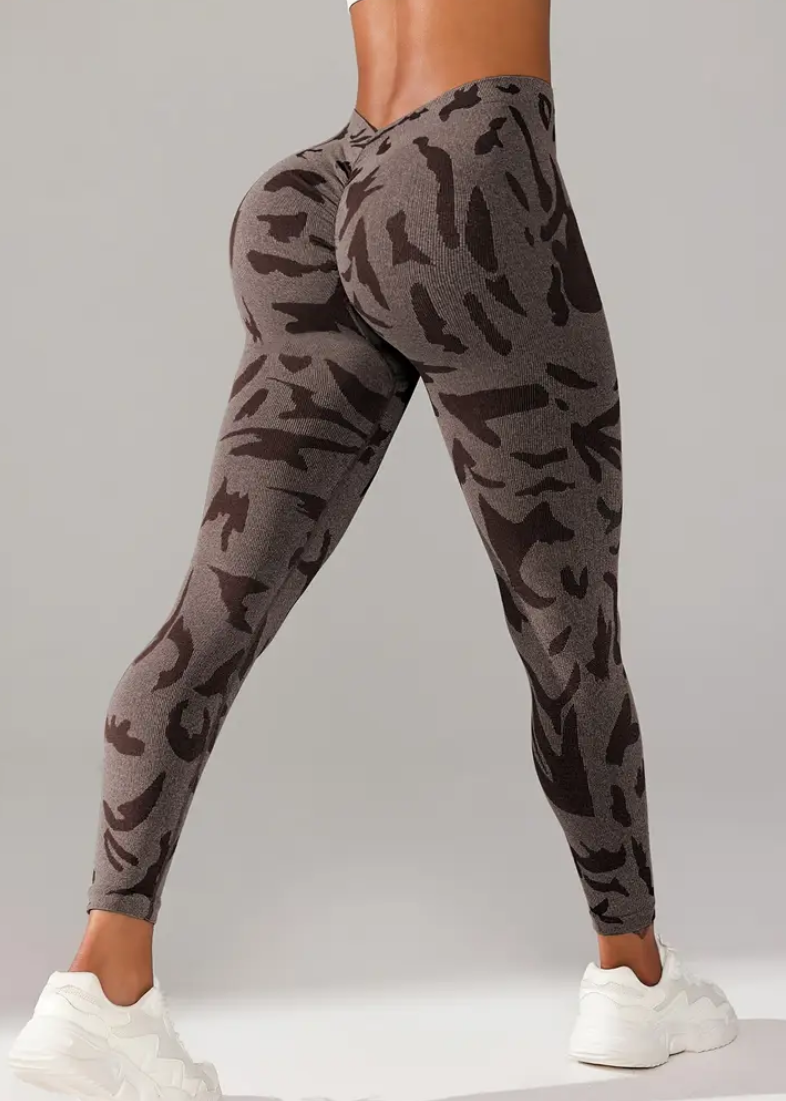 Person wearing camouflage jogger pants on a gray background