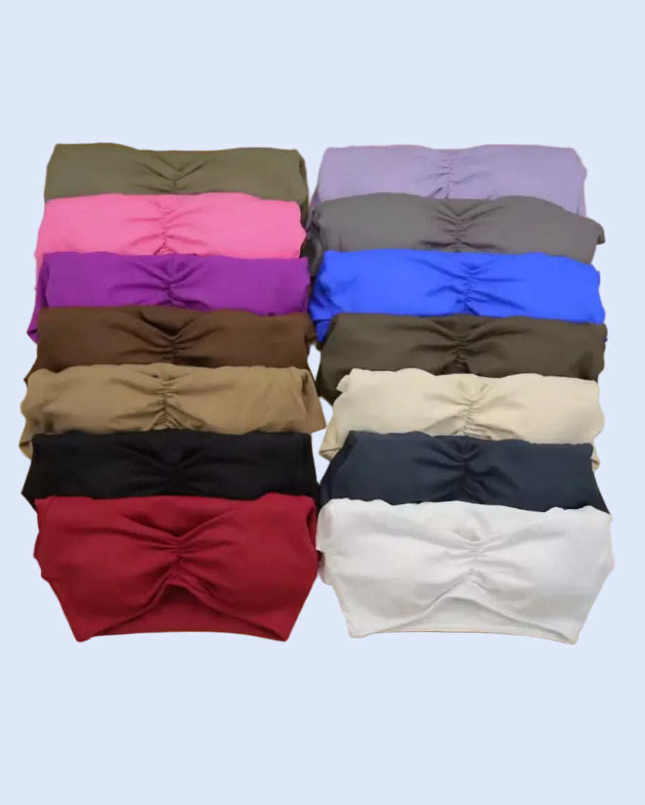 Eighteen strapless bandeau-style tops in multiple colors, neatly stacked in two columns of nine on a solid yellow background.