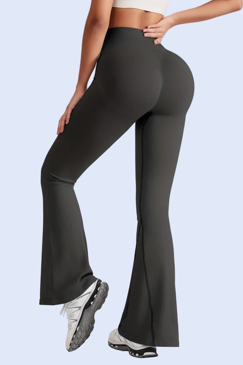 Person wearing black flared pants on a light gray background