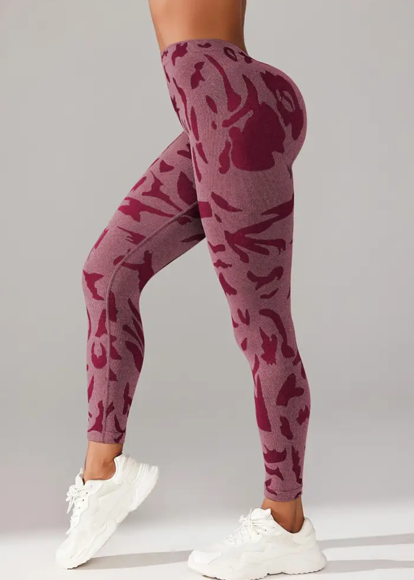 Maroon camouflage leggings worn by a person on a gray background