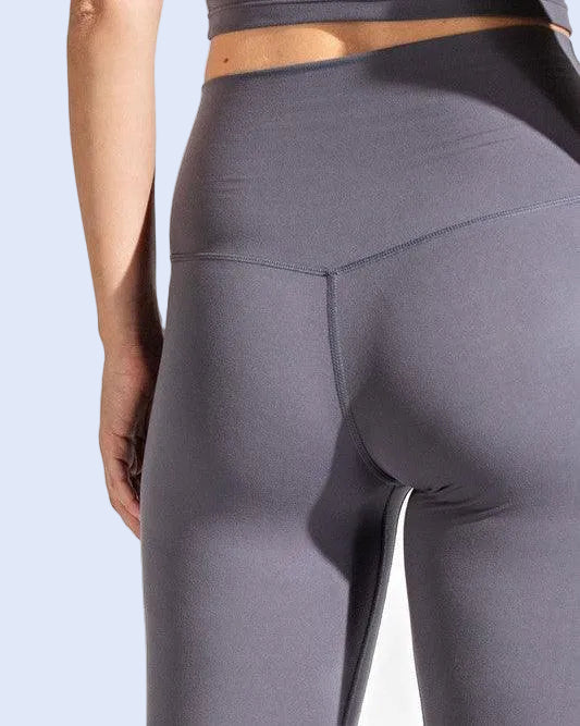 Gray leggings worn by a person on a white background