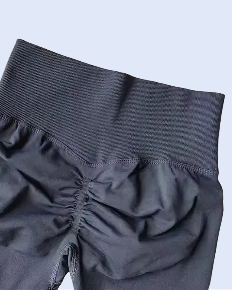 Dark gray shorts with a textured waistband on a light gray background