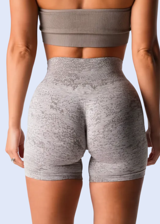 Person wearing gray athletic shorts and top on a white background