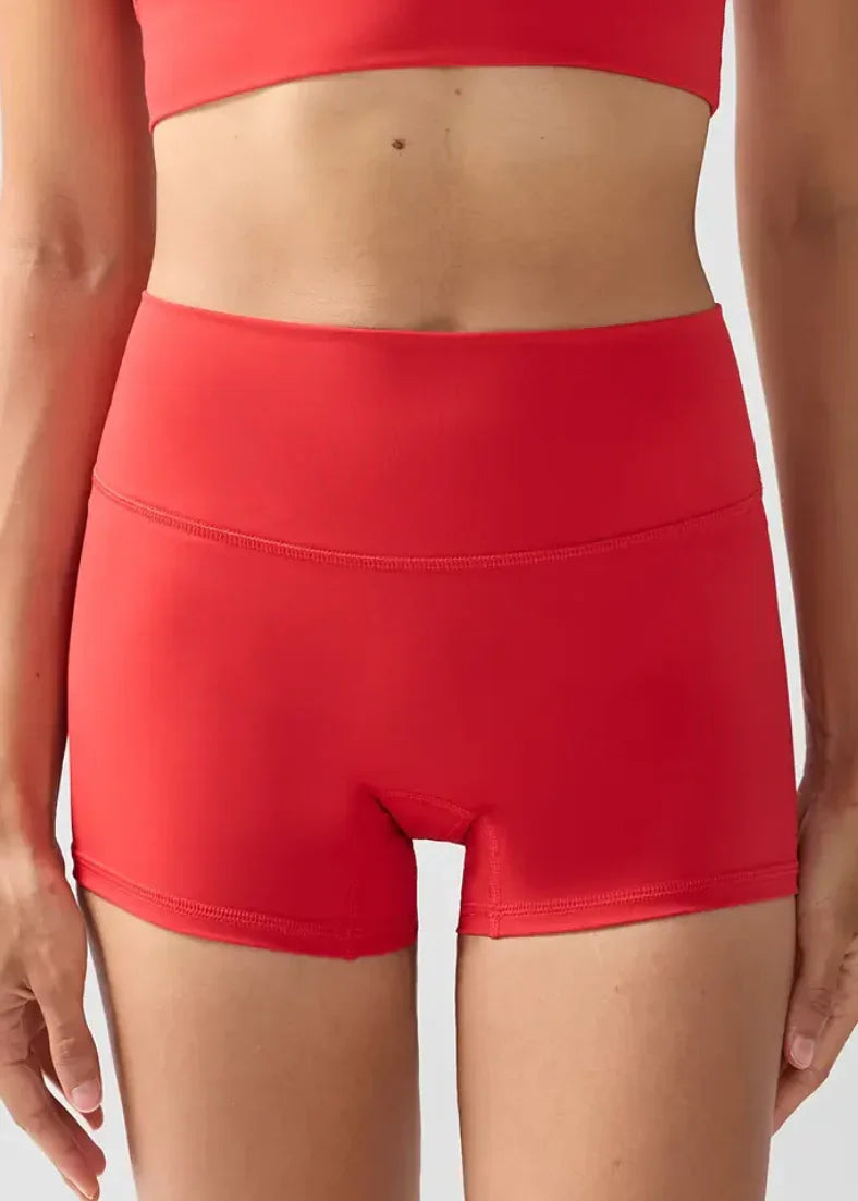 Red athletic shorts on a person against a white background