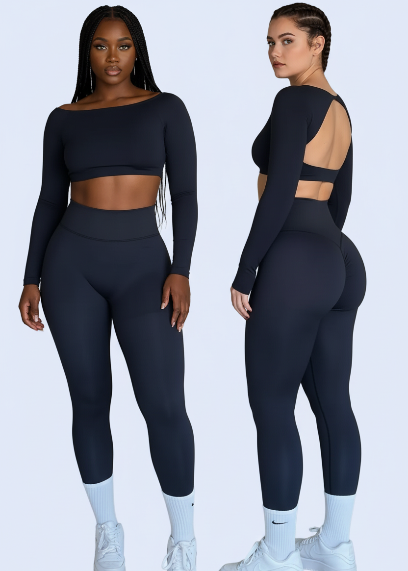 Woman modeling a black long-sleeve top and leggings set in front of a mirror.