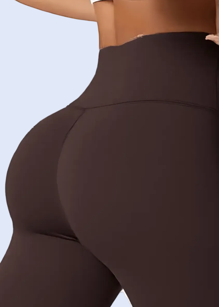 Brown leggings being worn on a white background