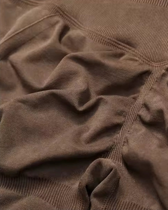 Close-up of a brown textured fabric garment showing the waistband and side seam details.