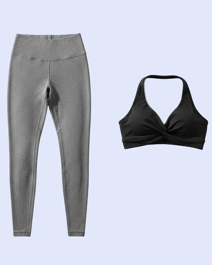 Gray leggings and black sports bra on a light blue background