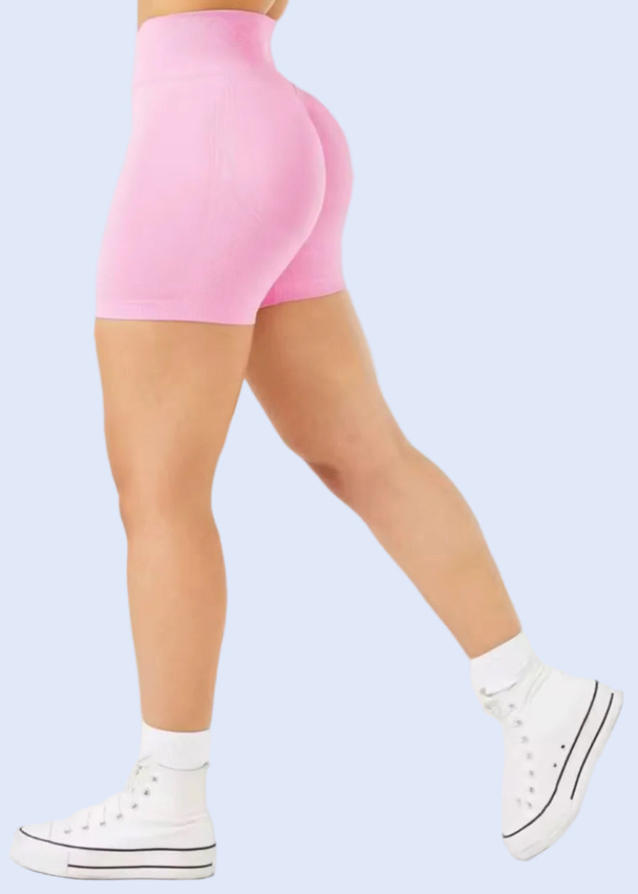 Person wearing pink high-waisted shorts on a white background