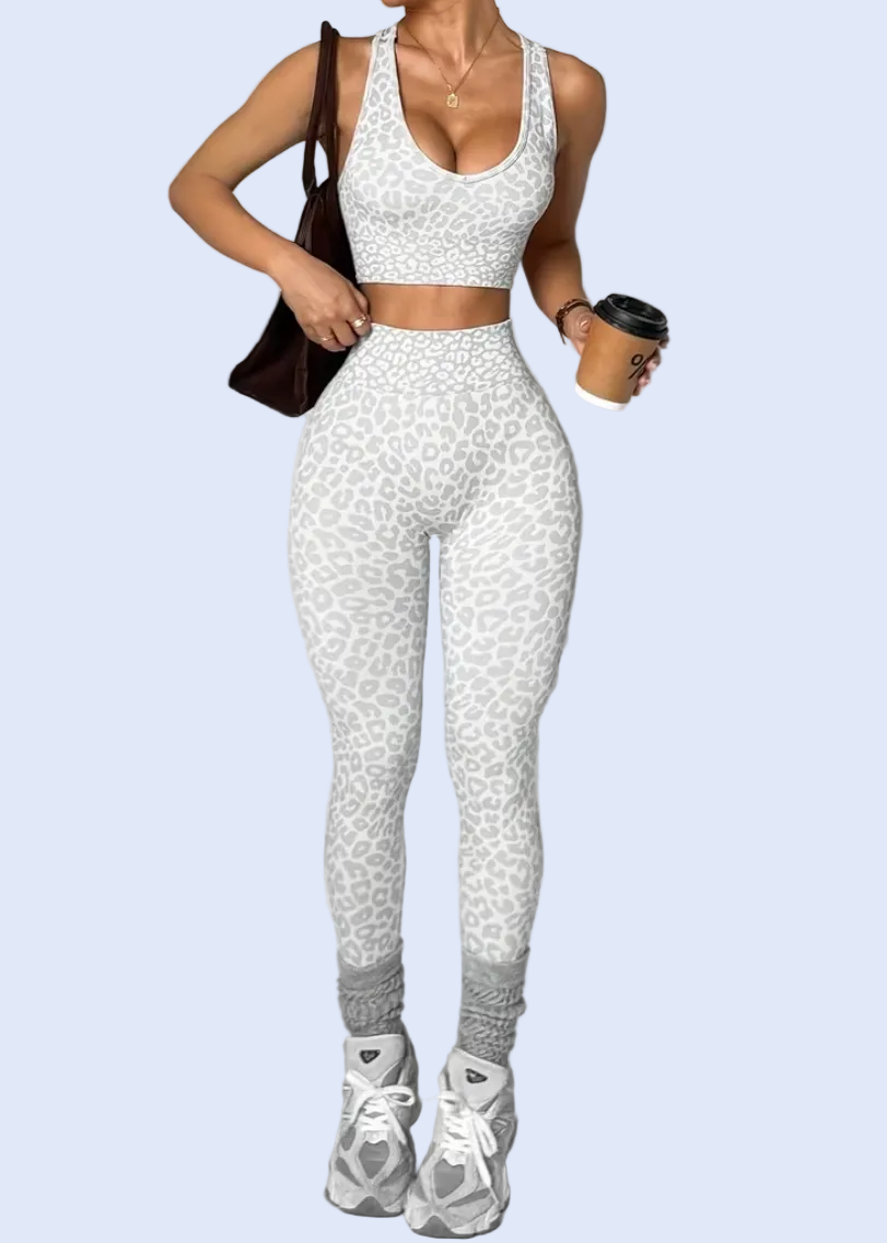 Woman in white athletic wear holding a black bag and cup on a gray background