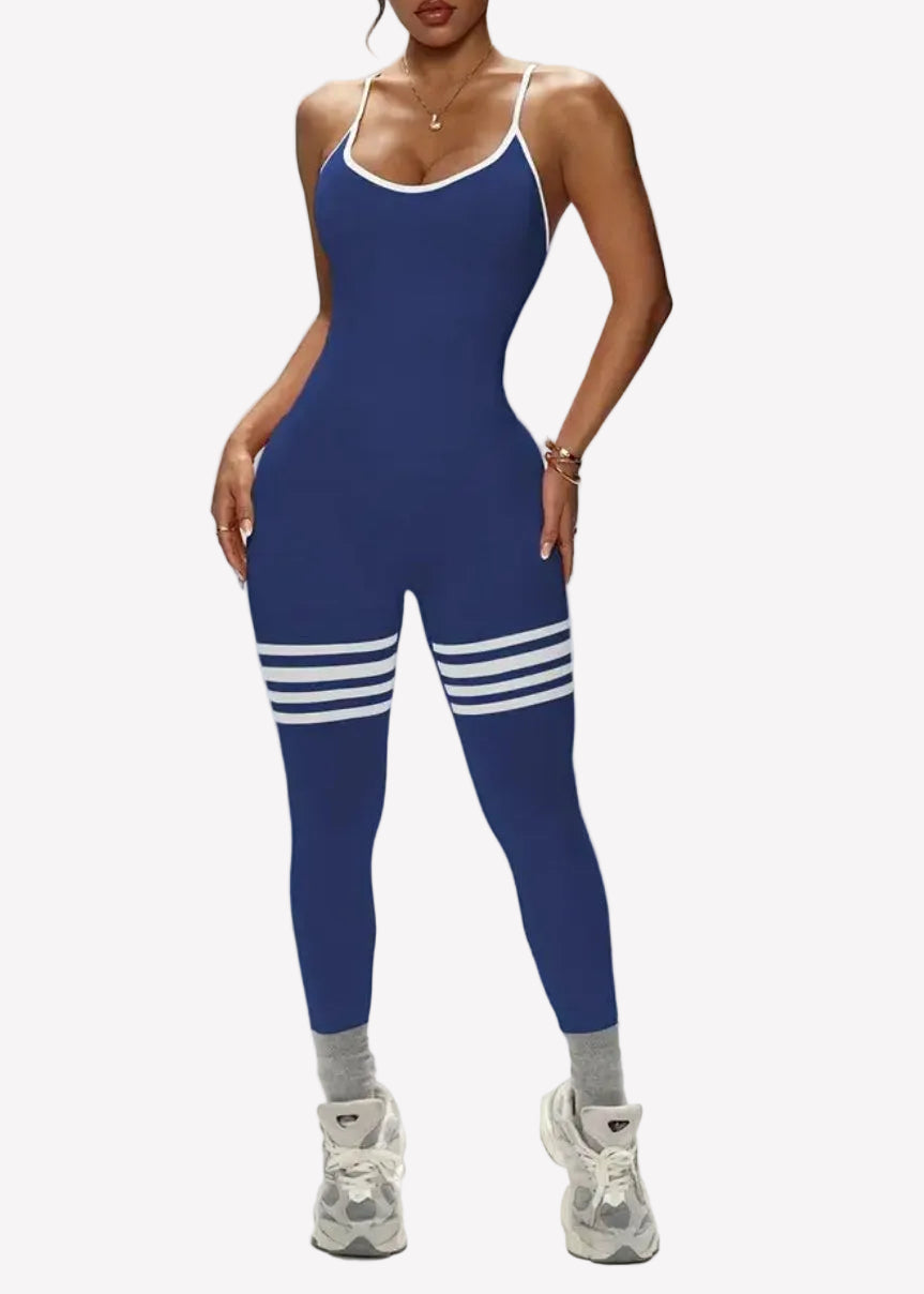 Woman wearing a blue jumpsuit with white stripes on a gray background