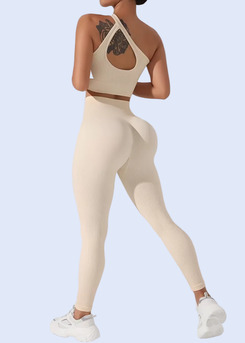 Woman wearing a beige athletic outfit on a gray background
