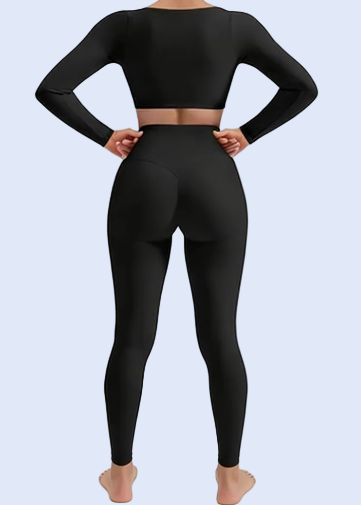 Person wearing a black long-sleeve top and leggings on a white background