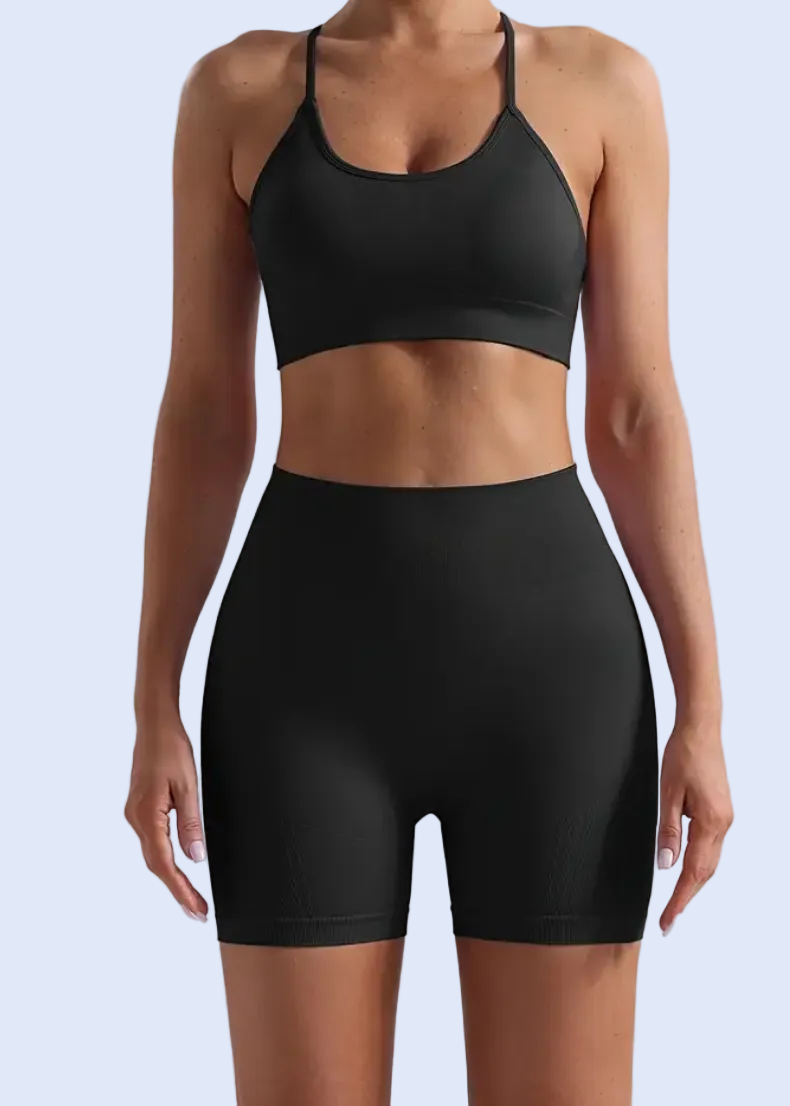 Person wearing a black sports bra and shorts on a light gray background