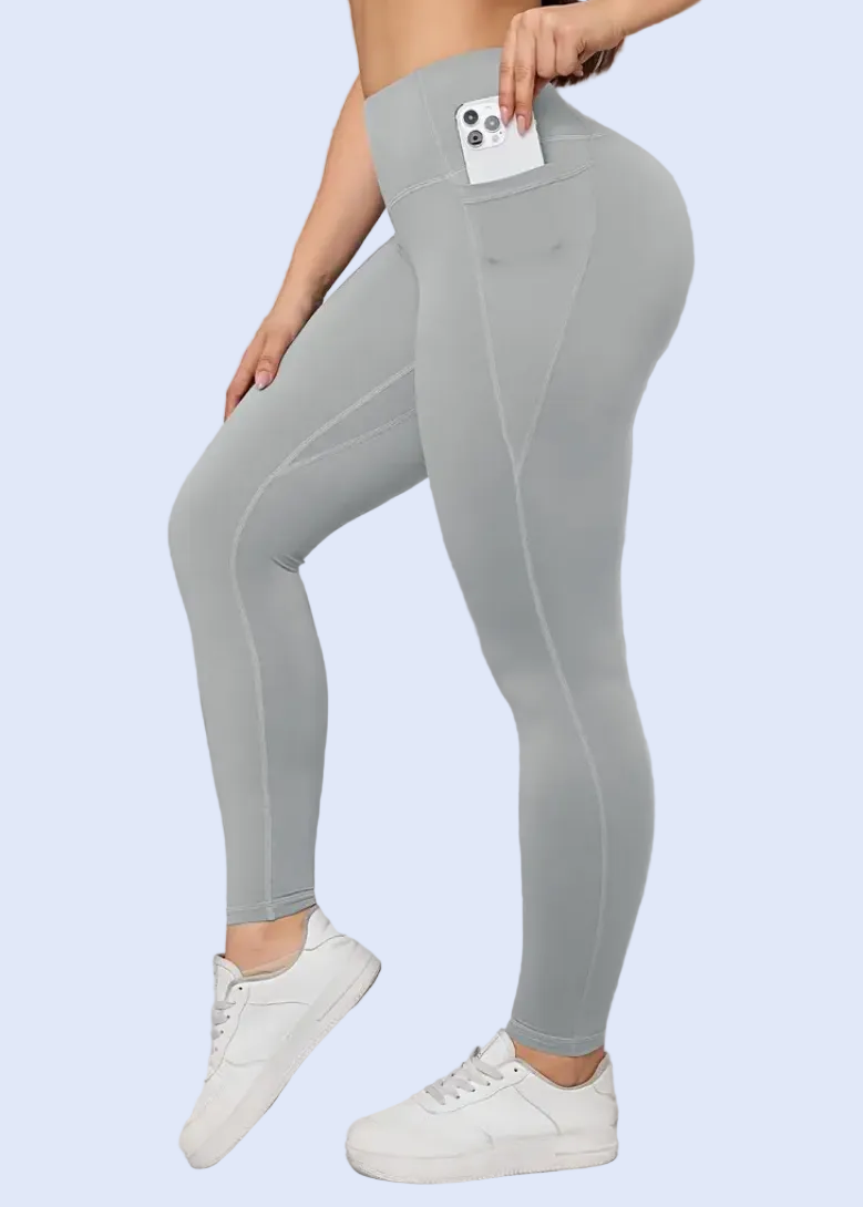 Person wearing gray leggings and white sneakers against a light gray background