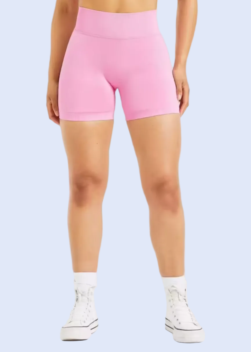 Person wearing pink high-waisted shorts on a white background