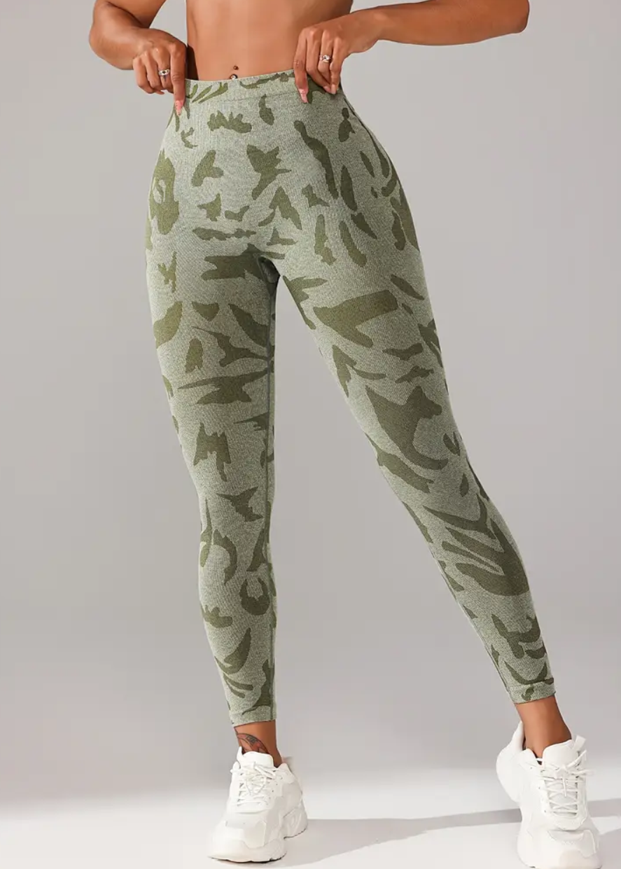 Person wearing green camouflage jogger pants on a gray background
