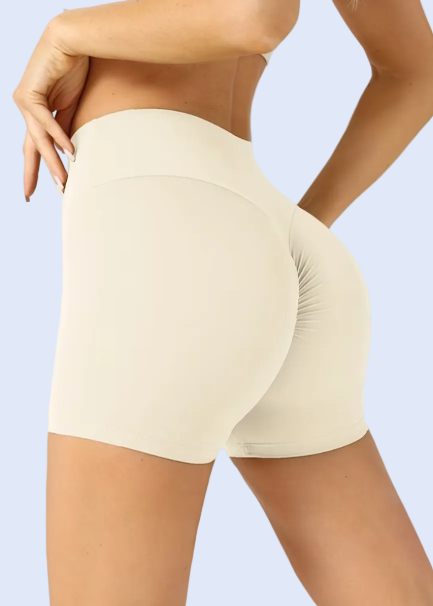 Beige shorts worn by a person on a white background