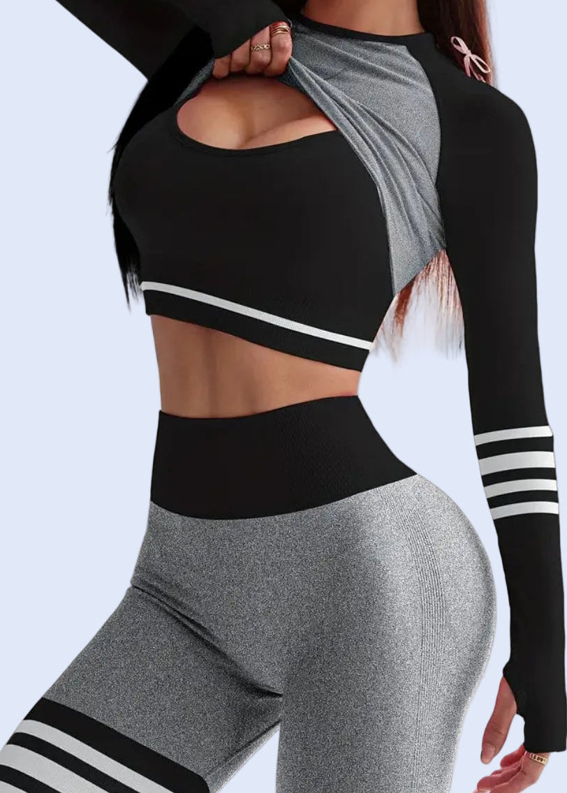 Person wearing a black and gray athletic outfit with white stripes on a light gray background