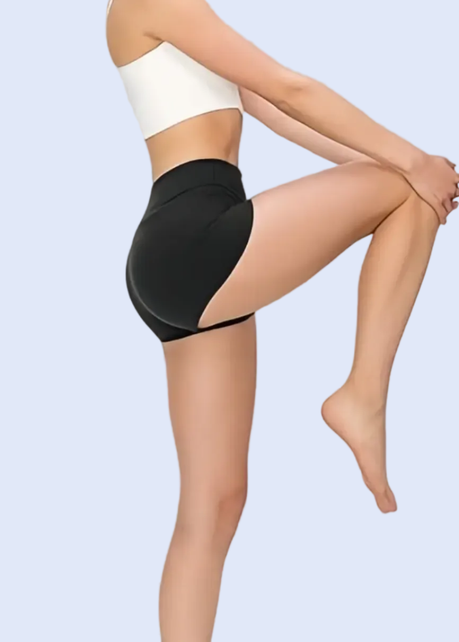 Person wearing black tights and white top on a gray background