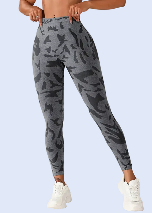 Person wearing gray camouflage leggings on a plain background