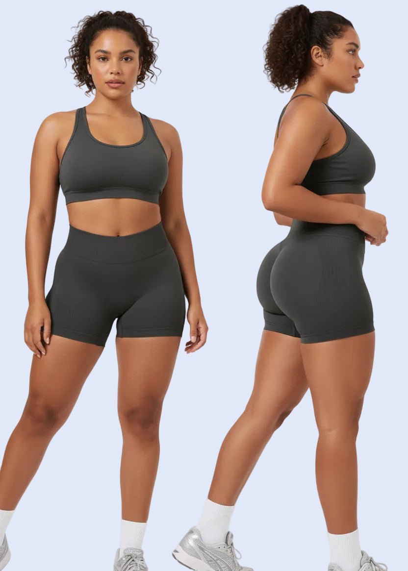 Person wearing black athletic shorts and white sneakers on a light gray background