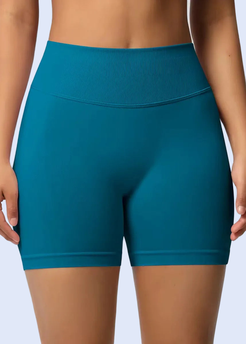 Teal athletic shorts worn by a person on a plain background
