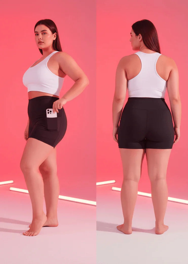 Woman wearing a white sports bra and black shorts on a pink gradient background