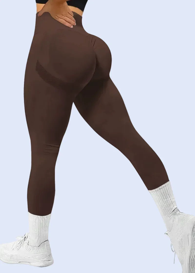 Person wearing brown leggings with a white background