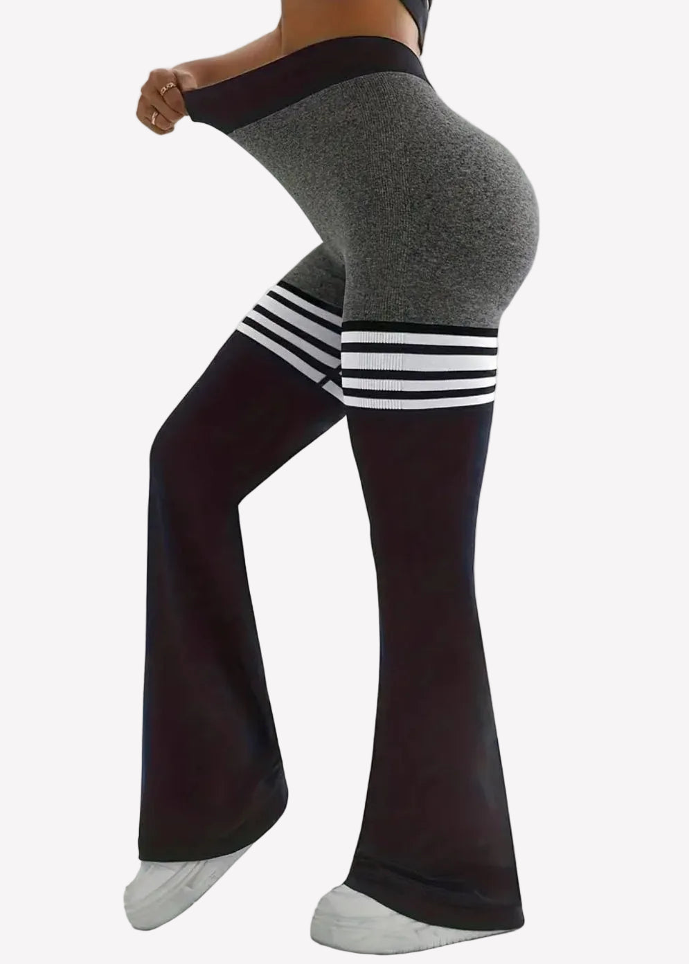 Person wearing gray leggings with black and white striped socks on a plain background