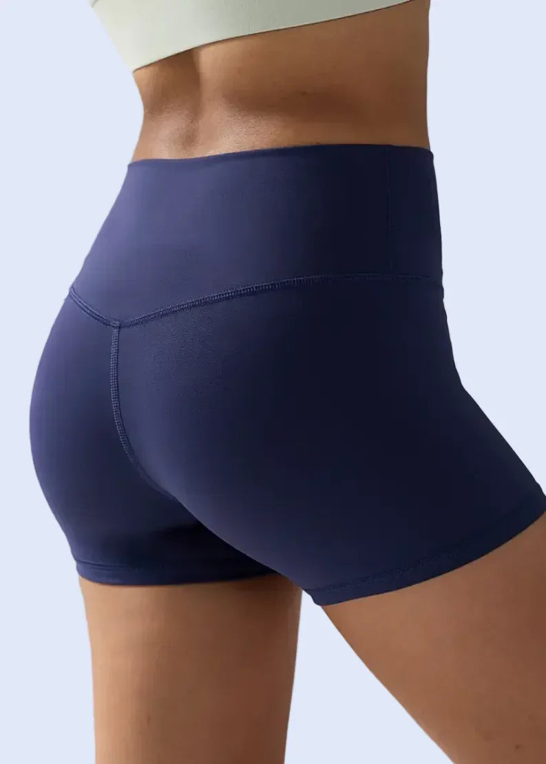 Navy blue athletic shorts worn by a person on a light gray background