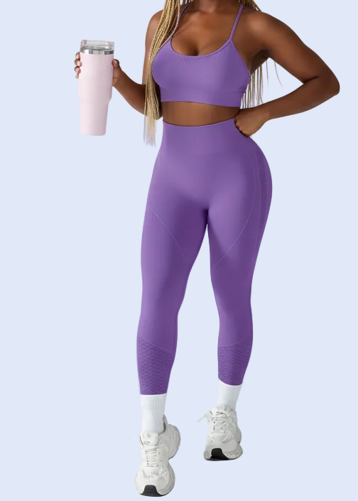 Woman in purple athletic wear holding a pink water bottle on a light gray background