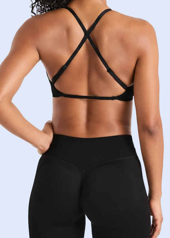 Person wearing a black strappy top and leggings on a white background