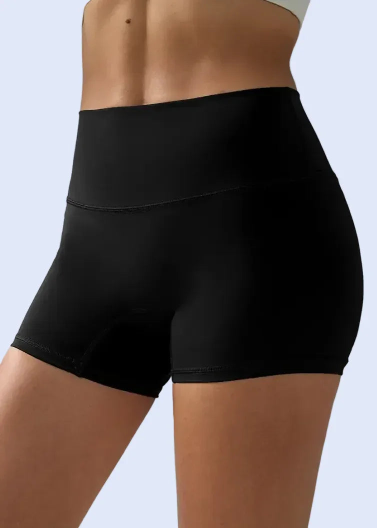 Black athletic shorts worn by a person on a gray background