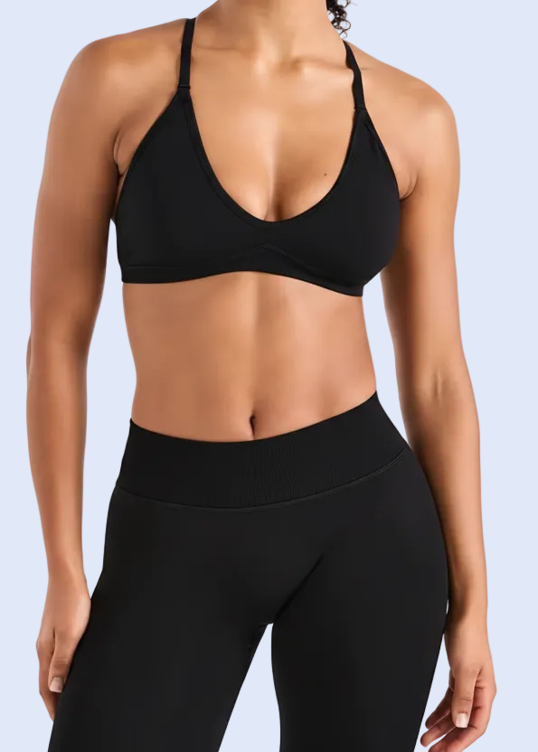 Person wearing a black sports bra and leggings on a white background