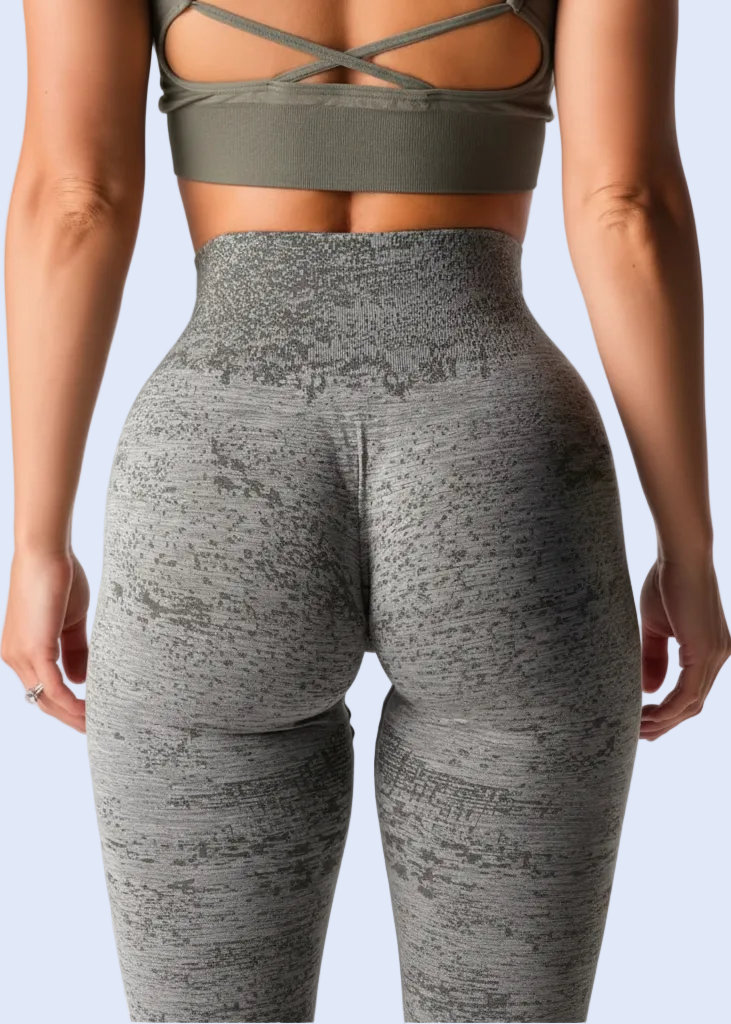 Person wearing a green sports bra and gray leggings on a plain background