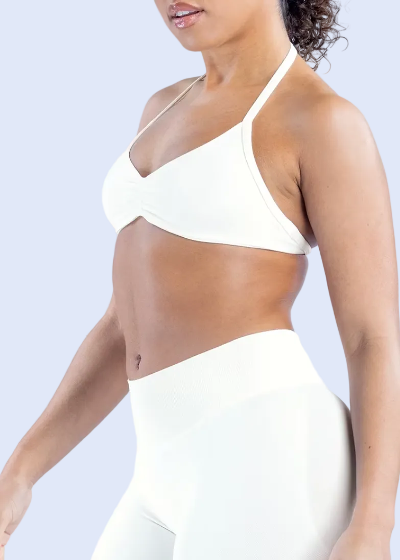 Woman wearing a white bikini against a light gray background
