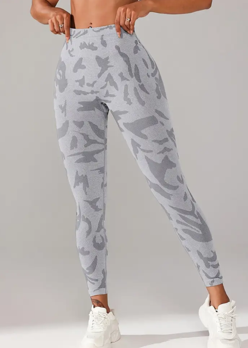 Person wearing light gray camouflage jogger pants on a plain background