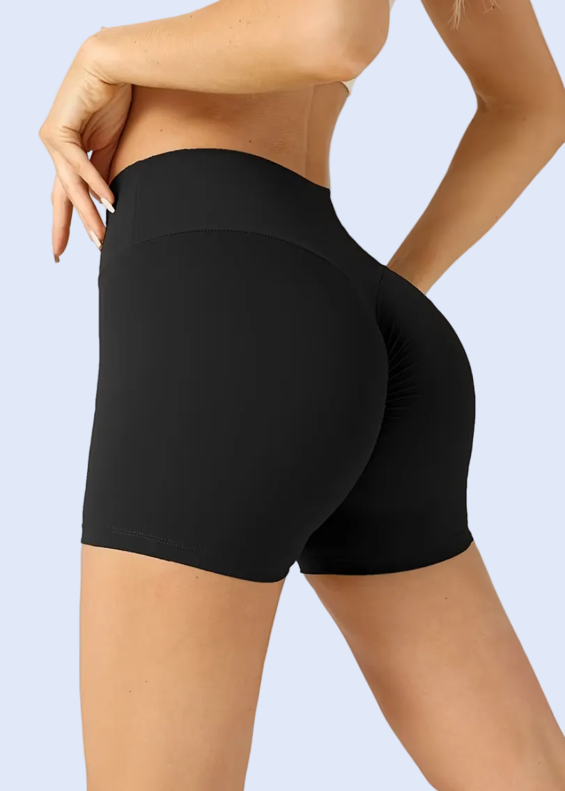 Black athletic shorts worn by a person on a plain background