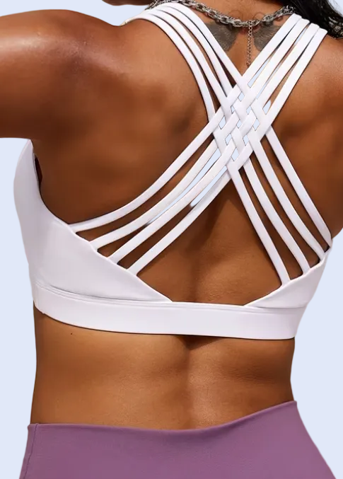 Person wearing a white sports bra and purple leggings with a tennis racket.