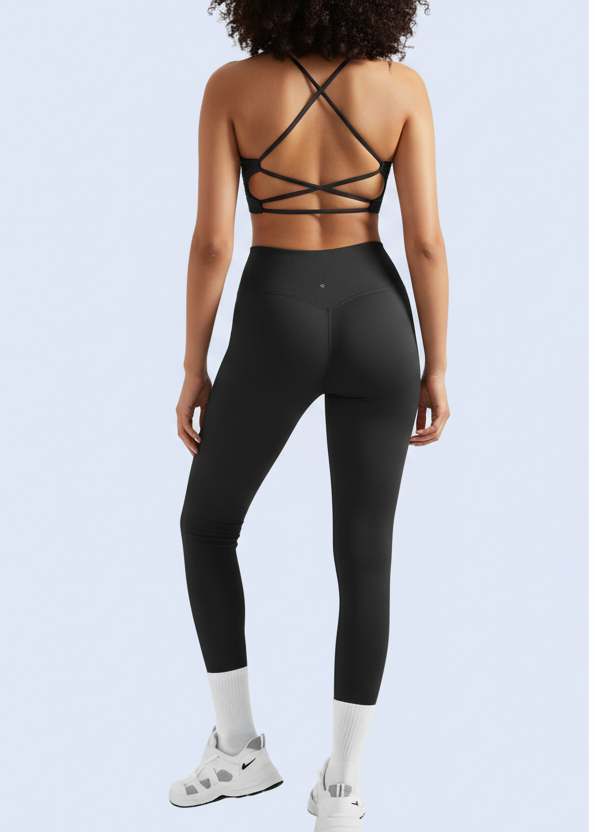 Person wearing black leggings with a strappy top on a white background