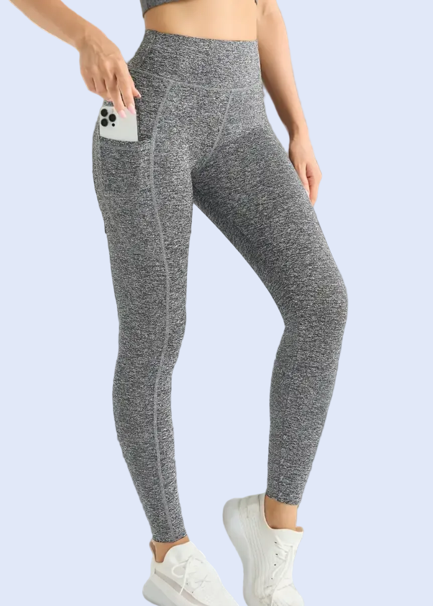 Person wearing gray leggings and a crop top in a minimalistic room.