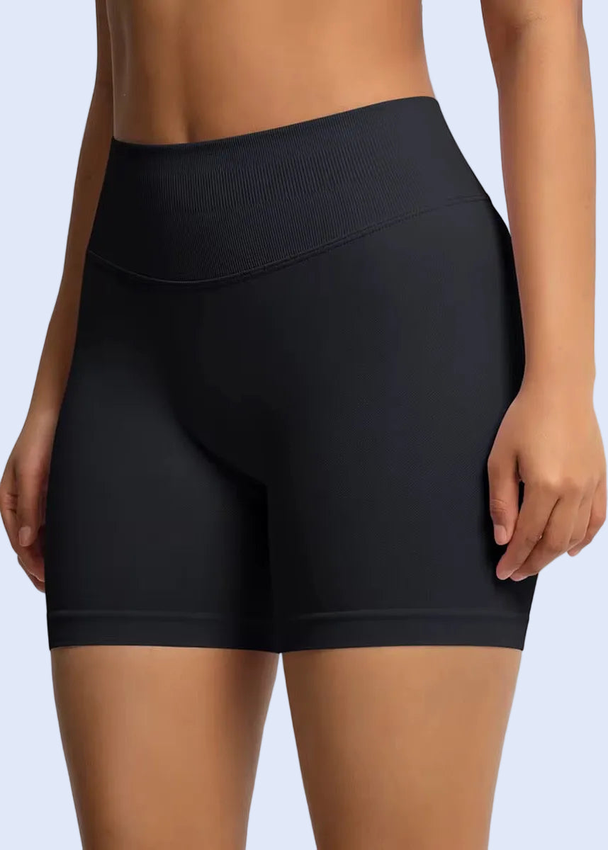 Black athletic shorts worn by a person on a light gray background