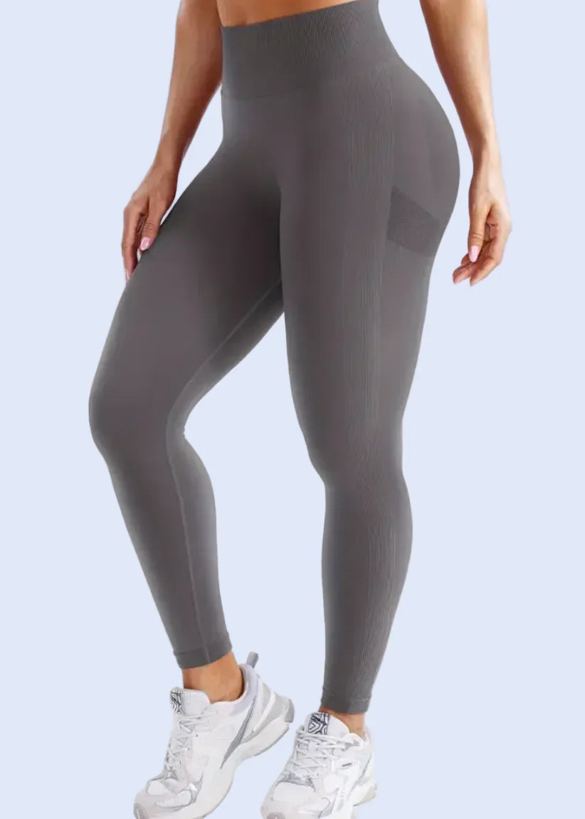 Person wearing gray leggings on a white background