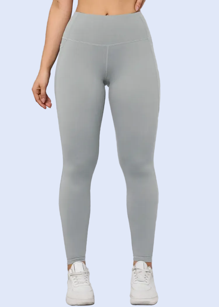 Person wearing gray leggings against a white wall