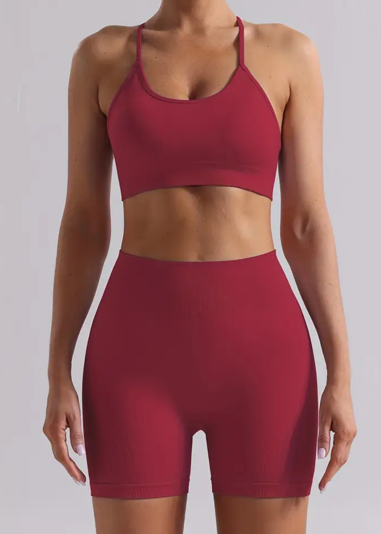 Person wearing a red sports bra and shorts on a light gray background