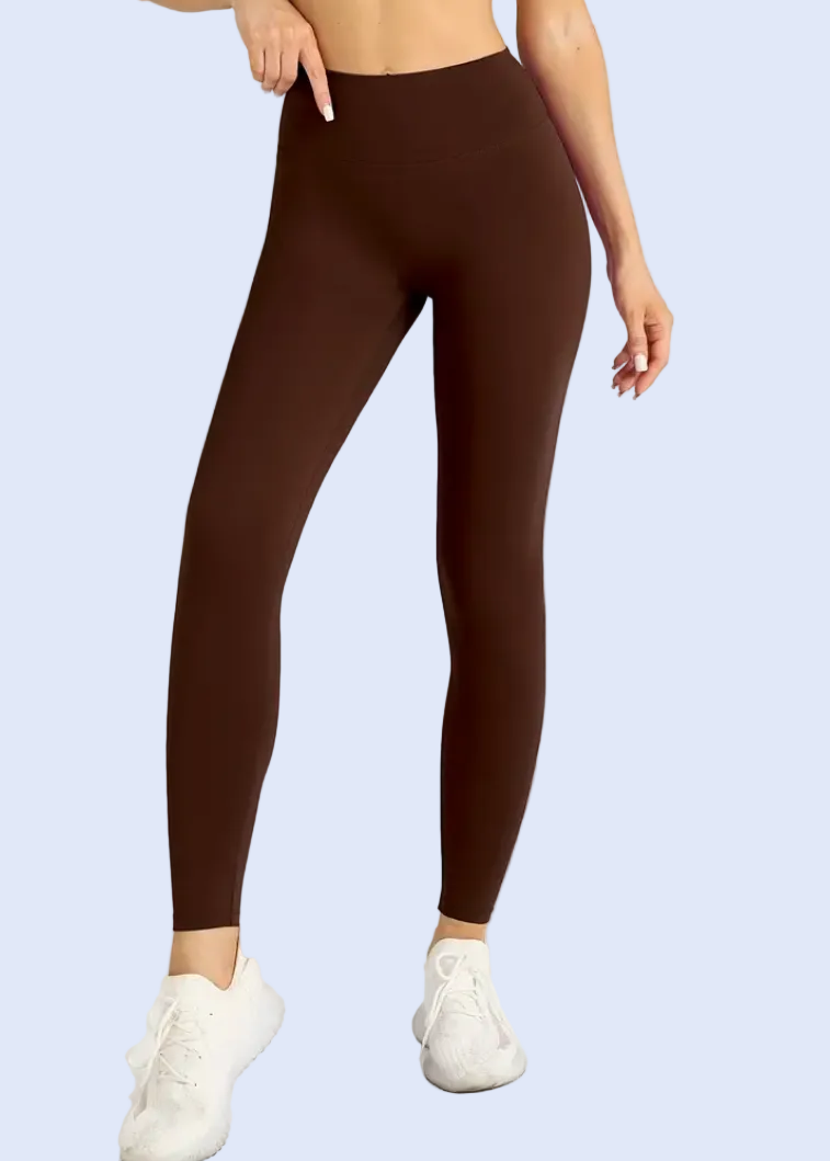 Person wearing brown leggings on a white background